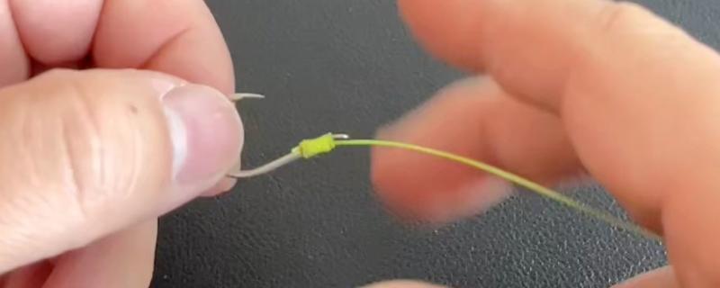 鱼钩怎样绑在鱼竿上，首先子线在钩柄中下部位置对折