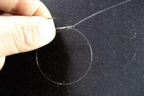 鱼钩怎样绑在鱼竿上，首先子线在钩柄中下部位置对折