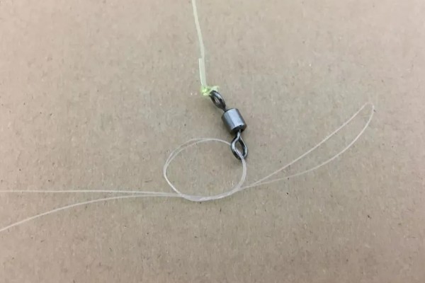 鱼钩怎样绑在鱼竿上，首先子线在钩柄中下部位置对折