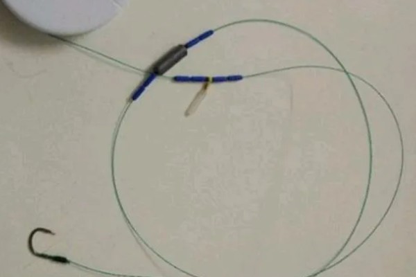 鱼钩怎样绑在鱼竿上，首先子线在钩柄中下部位置对折