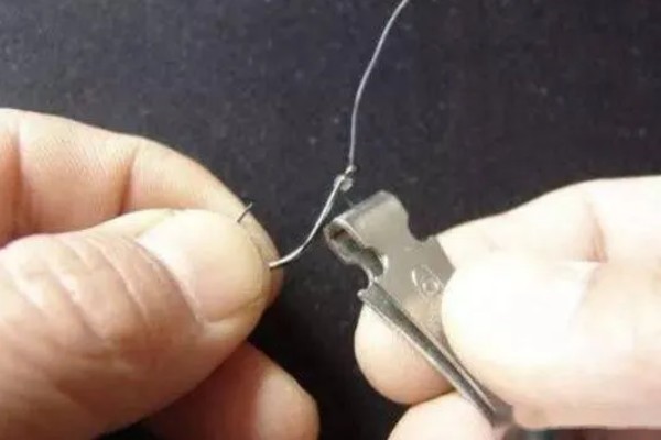 鱼钩怎样绑在鱼竿上，首先子线在钩柄中下部位置对折