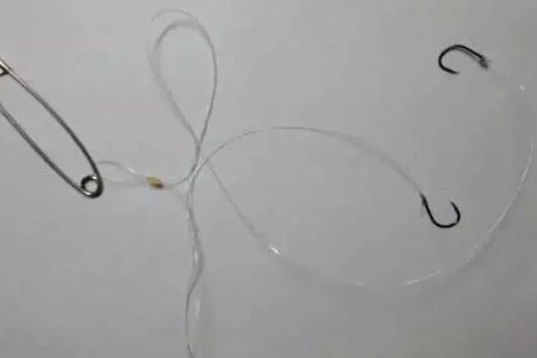 鱼钩怎样绑在鱼竿上，首先子线在钩柄中下部位置对折