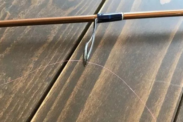 鱼钩怎样绑在鱼竿上，首先子线在钩柄中下部位置对折