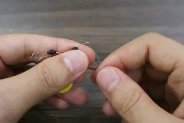 鱼钩怎样绑在鱼竿上，首先子线在钩柄中下部位置对折